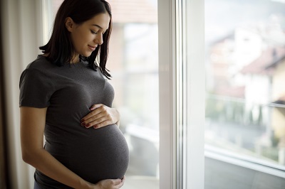 woman holding belly while pregnant